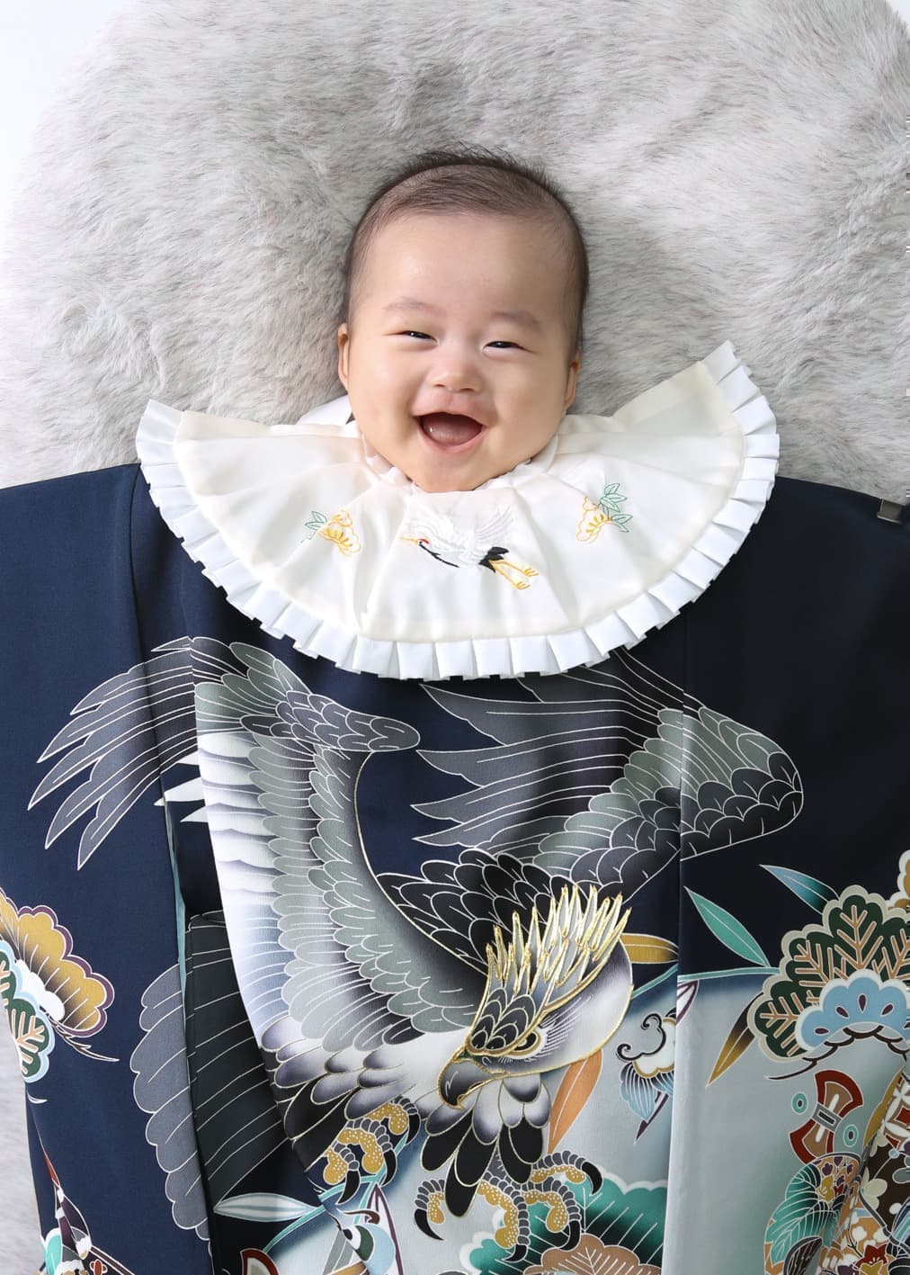 初着をかけて笑ってる１００日の赤ちゃん